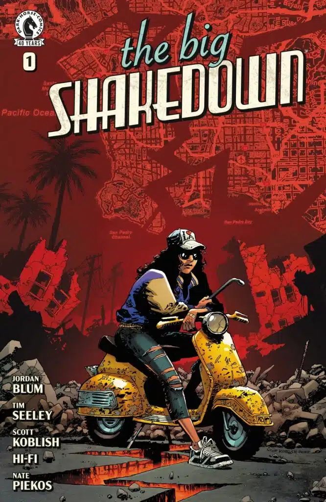 Comic book cover for 'The Big Shakedown #1' featuring a character on a yellow scooter, wearing sunglasses and a blue jacket, against a backdrop of a fragmented city landscape.