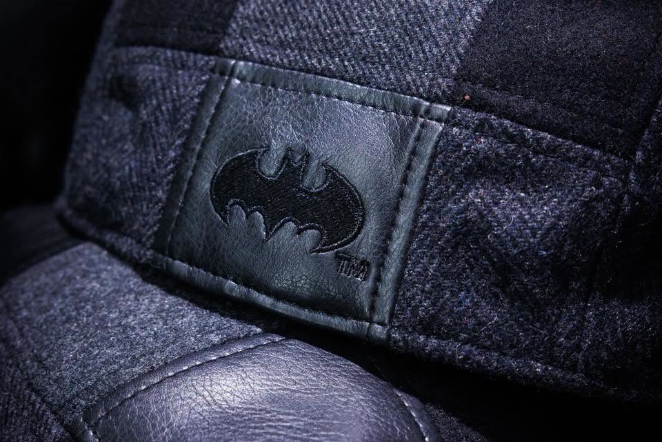 Close-up of a black hat featuring the Batman logo embossed on a leather patch.