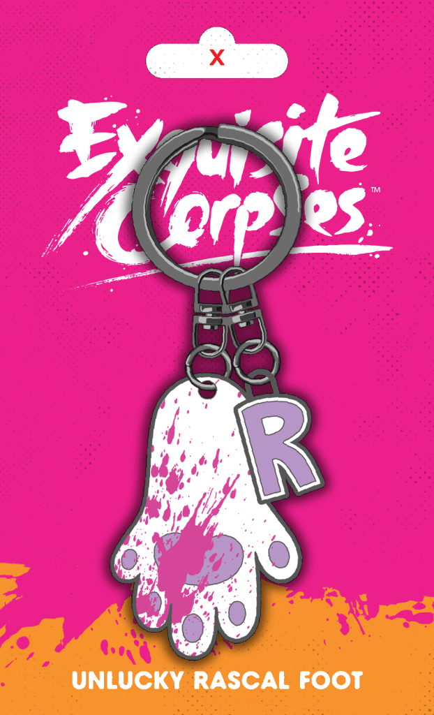 Keychain featuring a whimsical design of a foot with splashes of color and a letter 'R', set against a bright pink background with the text 'Exquisite Corpse' and 'Unlucky Rascal Foot'.