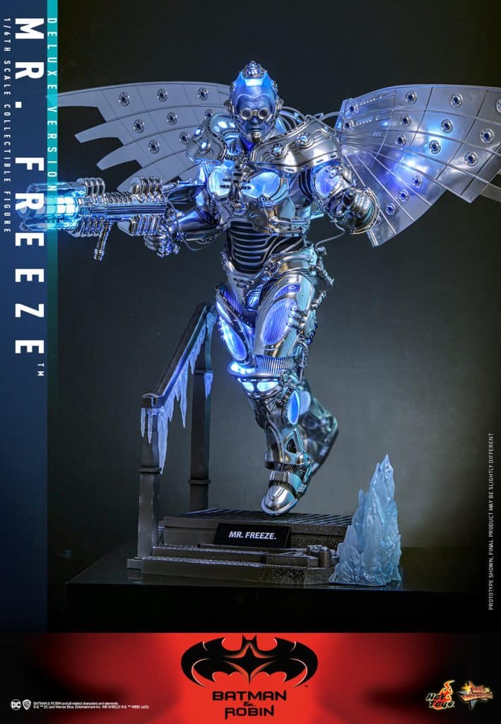 A detailed collectible figure of Mr. Freeze from Batman & Robin, featuring metallic armor, an icy blue glow, and an elaborate gun. The figure stands on a base with icicle accents and displays the character's name.