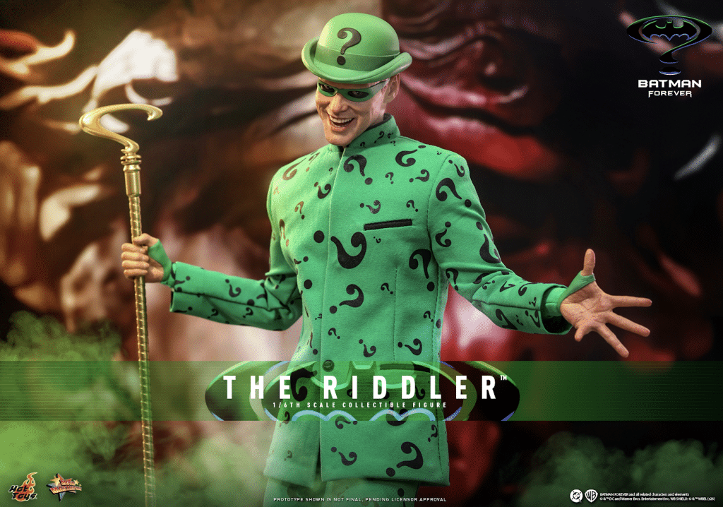 A collectible figure of The Riddler, wearing a green suit adorned with question marks and a matching bowler hat, holding a cane. The background features a mysterious and colorful design.