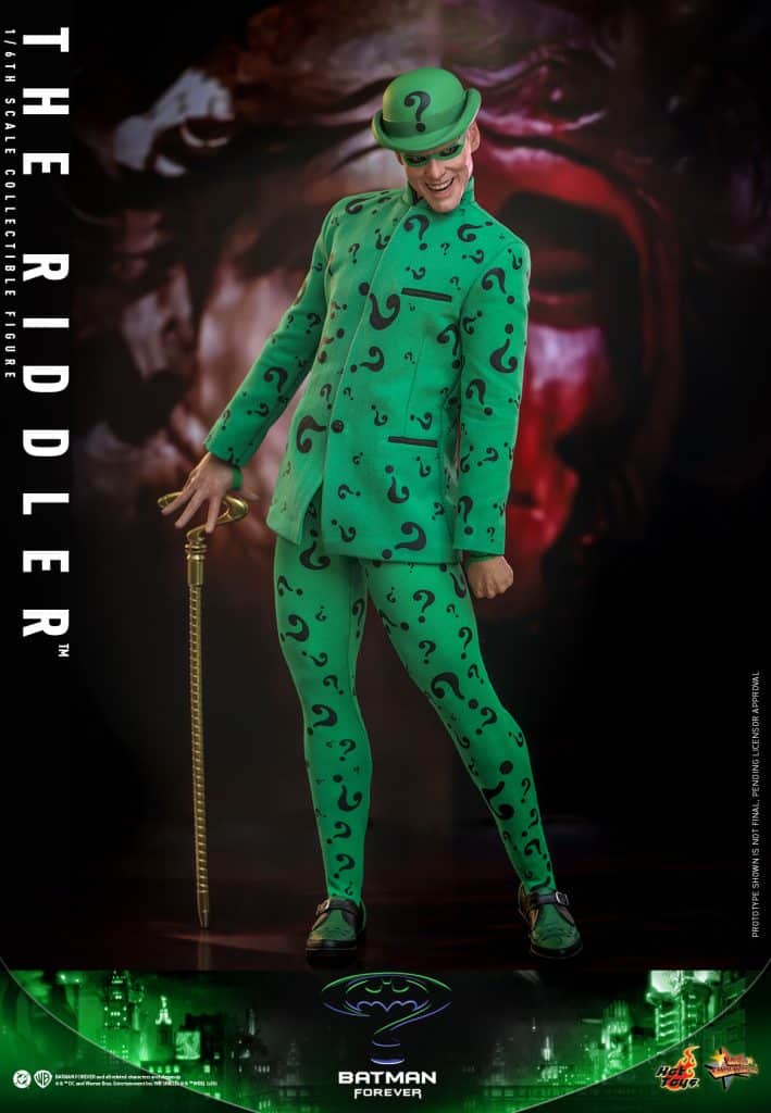 A detailed collectible figure of The Riddler from Batman Forever, dressed in a vibrant green suit adorned with question marks, holding a cane, and striking a playful pose.