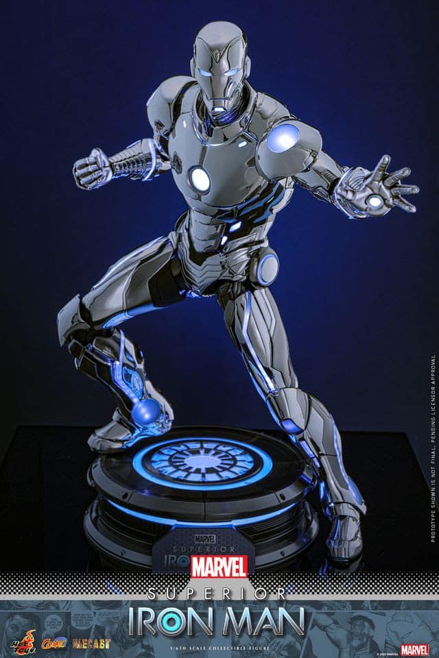 A detailed collectible figure of the Superior Iron Man, posed dynamically with a metallic finish and glowing blue accents, displayed on a circular base with the Iron Man emblem.