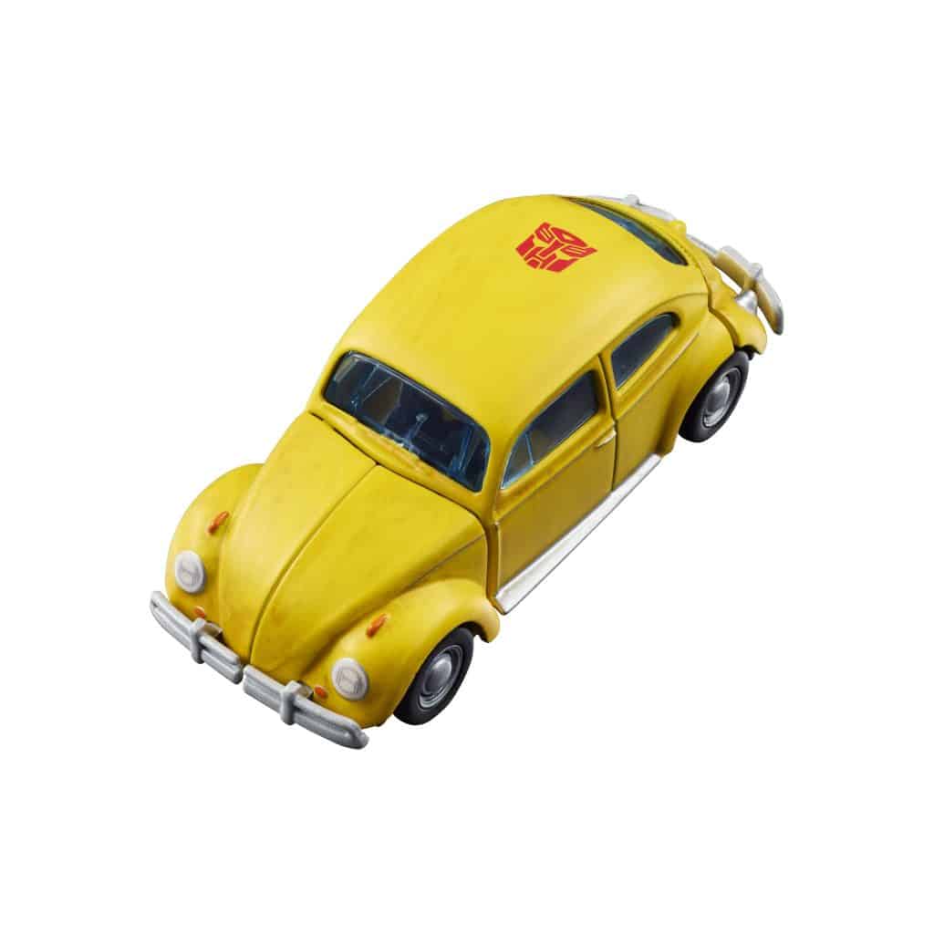 A yellow toy car resembling a vintage Volkswagen Beetle, featuring a red emblem on the roof.