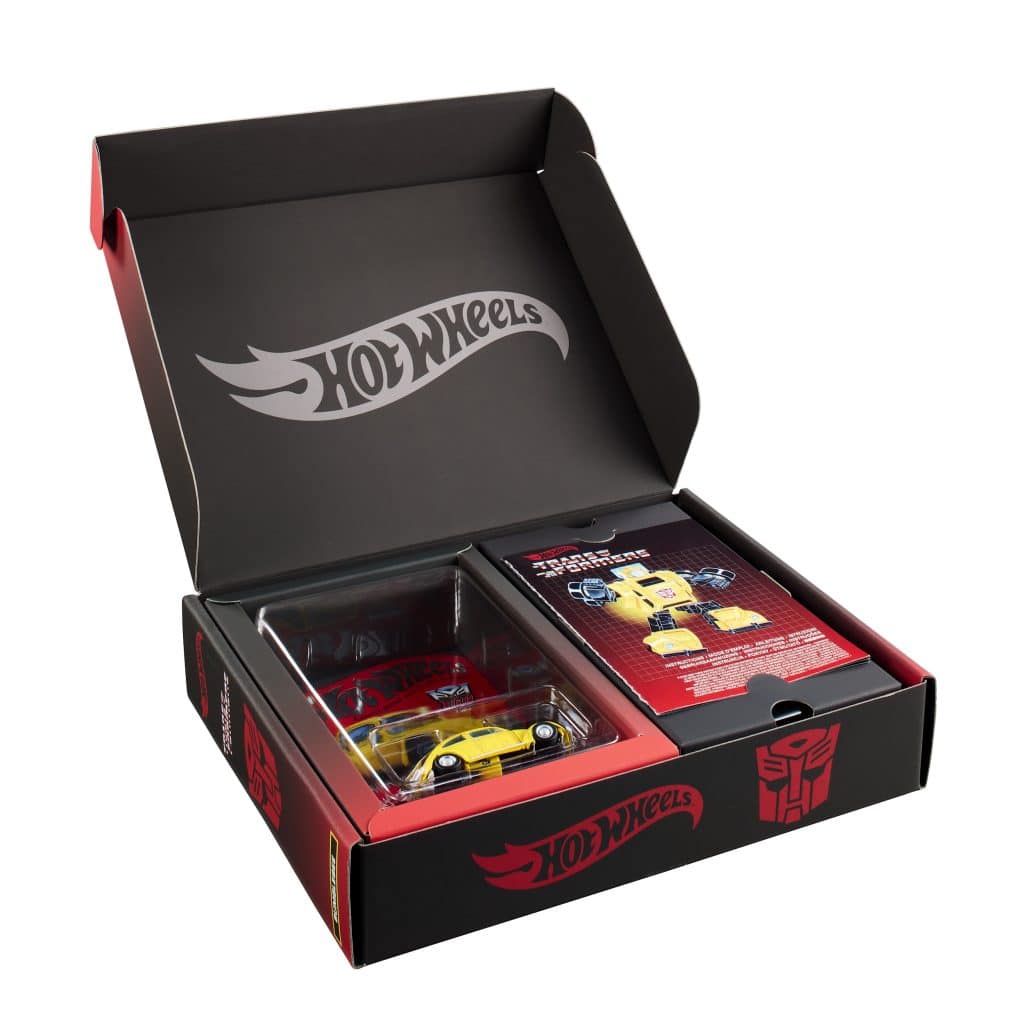 Open box featuring a Hot Wheels toy car and Transformers branding, with the car prominently displayed inside a clear plastic container.