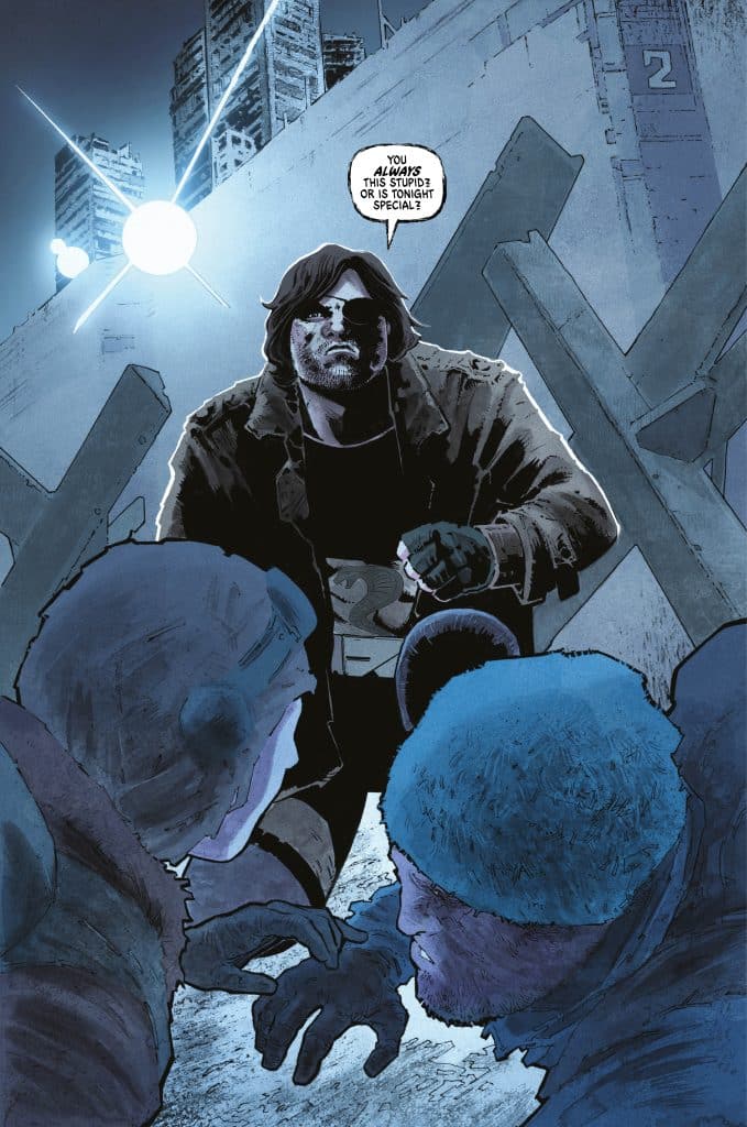 A muscular man in a dark coat confronts two huddled figures in a gritty, urban setting, illuminated by a bright light. The man appears to be questioning their intelligence.