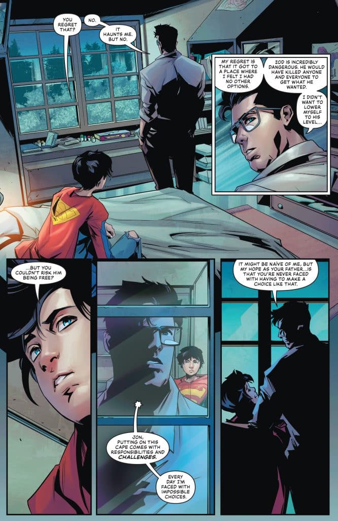 A comic panel featuring two characters in a room engaged in a serious conversation. One character, wearing glasses, stands with his back to the viewer, while the other character, a young boy in a superhero costume, looks up at him. The setting includes a window showing trees outside and personal items on a desk.