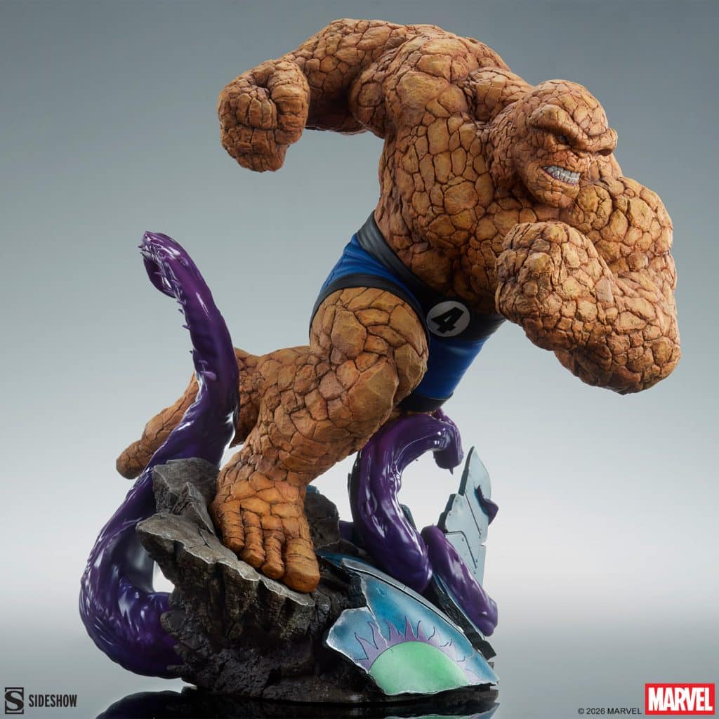 A detailed collectible statue of the superhero Thing from Marvel's Fantastic Four, showcasing his rocky texture and dynamic pose while fighting against a purple creature.