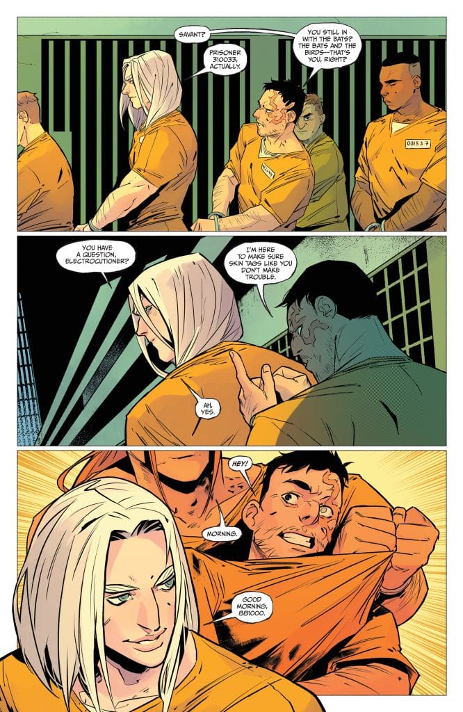 A comic book scene set in a prison, featuring several characters in orange jumpsuits. One character with long white hair speaks to others, while another character appears to be agitated. The dialogue includes discussions about a question and a greeting.