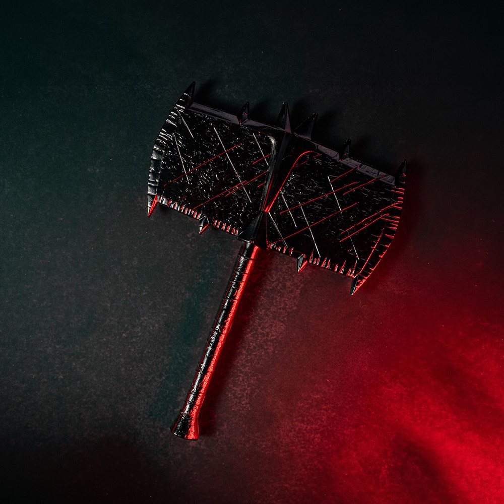 A double-headed axe with a dark, textured surface and sharp spikes on the edges, placed against a gradient background of dark green and red.