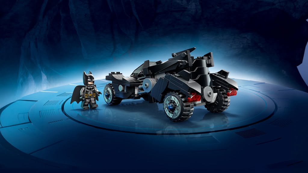 A LEGO Batman figure stands next to a detailed black Batmobile against a blue and dark background.