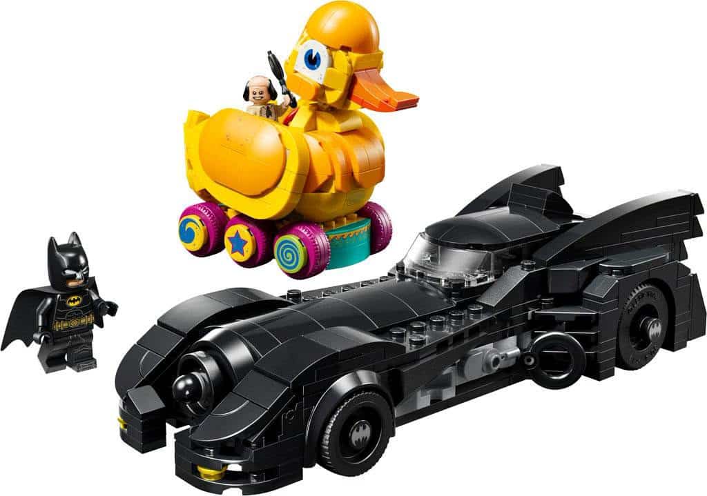 A set of LEGO figures and vehicles, including a black Batmobile, a Batman figure, and a colorful yellow rubber duck on wheels with a small figure riding it.