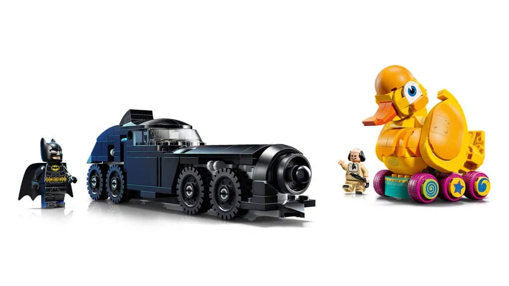 A scene featuring LEGO figures: Batman standing next to a large black vehicle and a character beside a colorful roller-skating rubber duck.