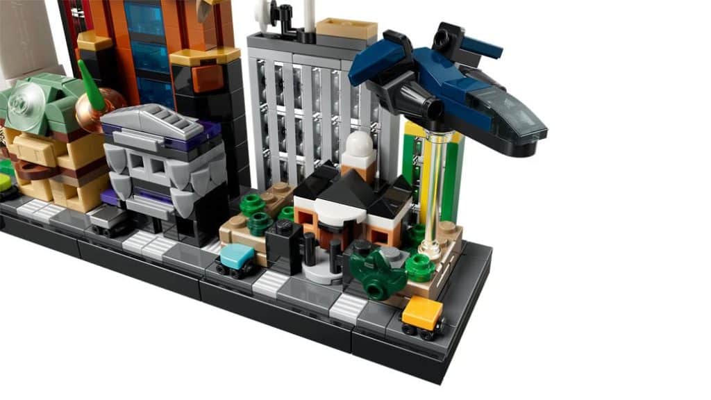 A detailed Lego city scene featuring various colorful buildings, vehicles, and a hovering blue craft.