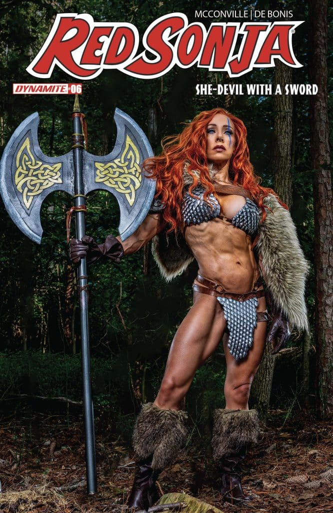 A muscular female warrior dressed in chainmail and fur, holding a large axe, stands confidently in a forest setting, showcasing the character Red Sonja on the cover of a comic book.