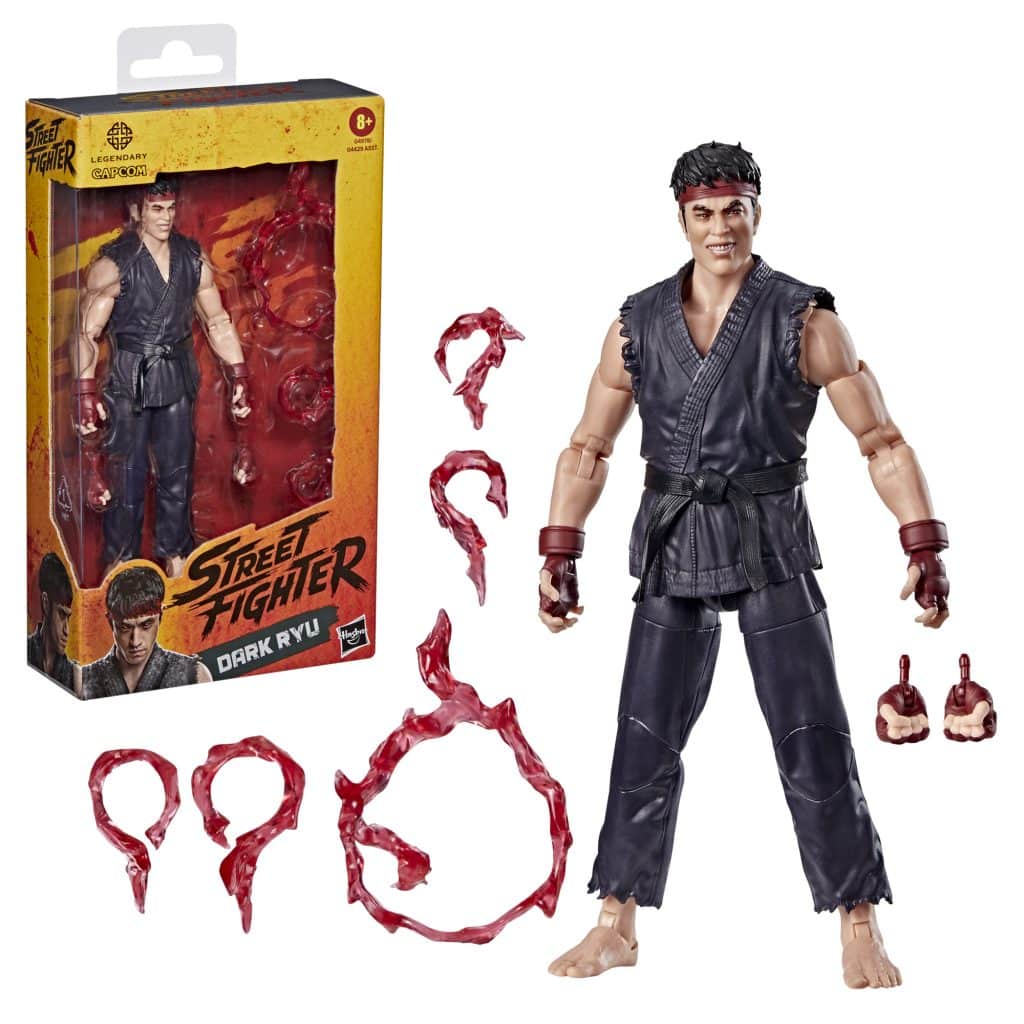 Action figure of Dark Ryu from Street Fighter, standing next to its packaging. The figure is dressed in a black martial arts outfit and has various accessories, including hands and energy effects in red.