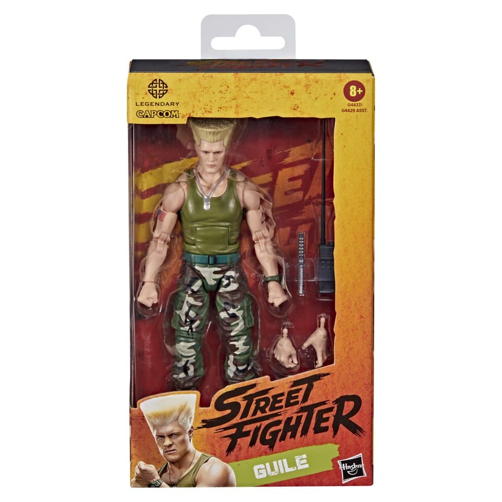 Action figure of Guile from Street Fighter, featuring military attire and multiple accessories, packaged in a colorful box.