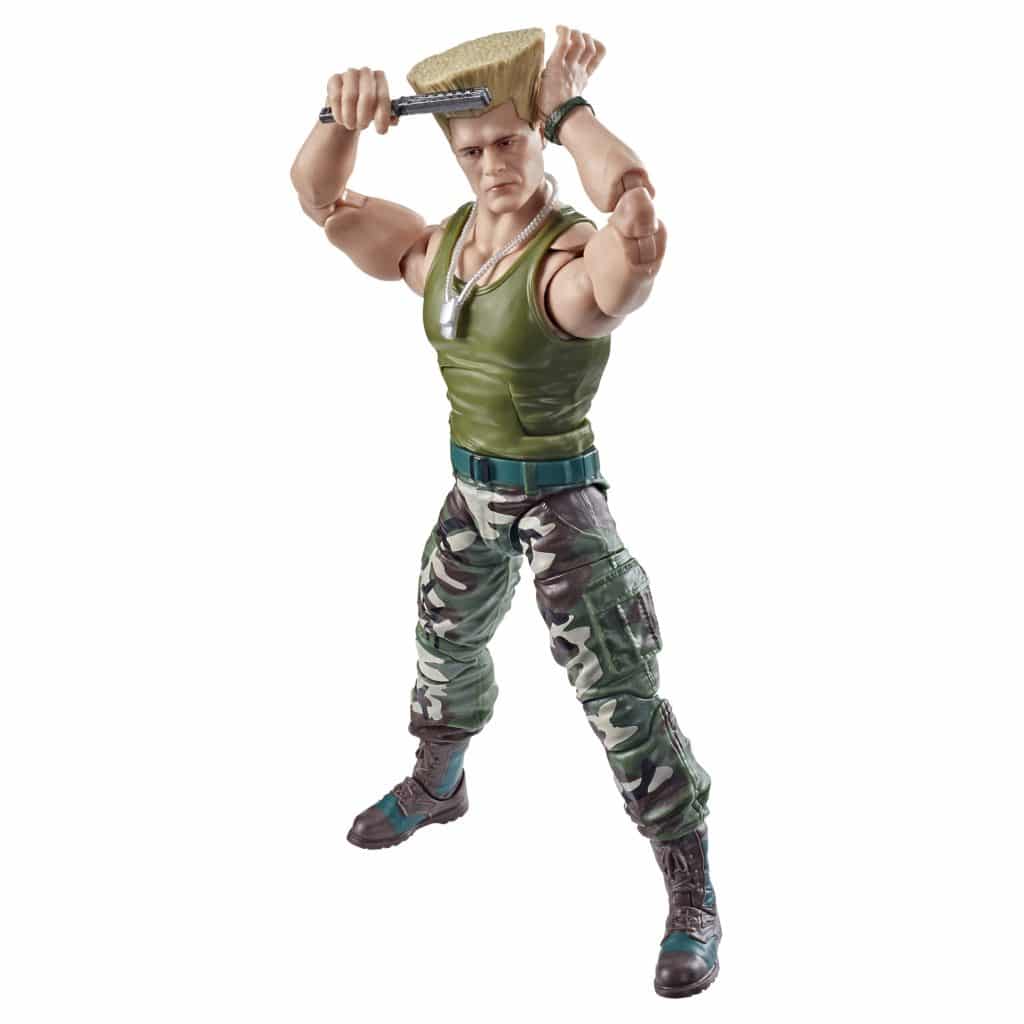 An action figure of a muscular soldier wielding a weapon, wearing a green tank top and camouflage pants, posed ready for battle.