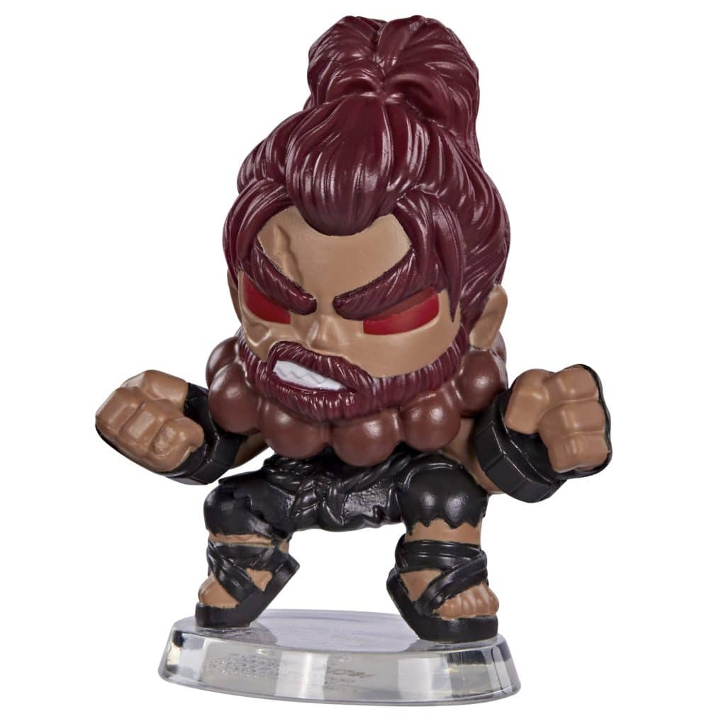A stylized collectible figure of a muscular warrior with long, reddish-brown hair, wearing a dark outfit and a distinctive beard, posed in a fighting stance.