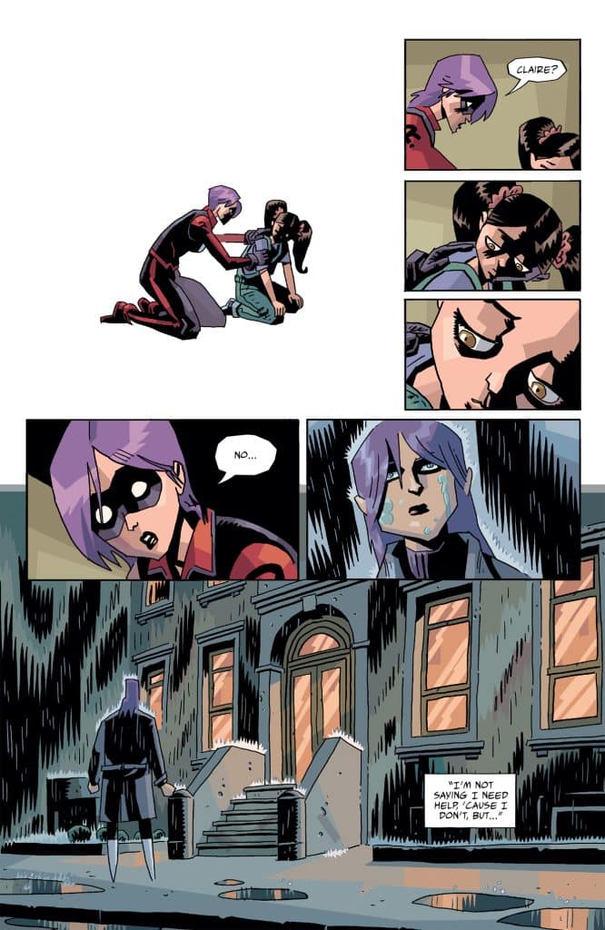 A comic panel depicting a character in a mask comforting another character who appears distressed. They are outside a building with rain and puddles around. The facial expressions convey concern and sadness.