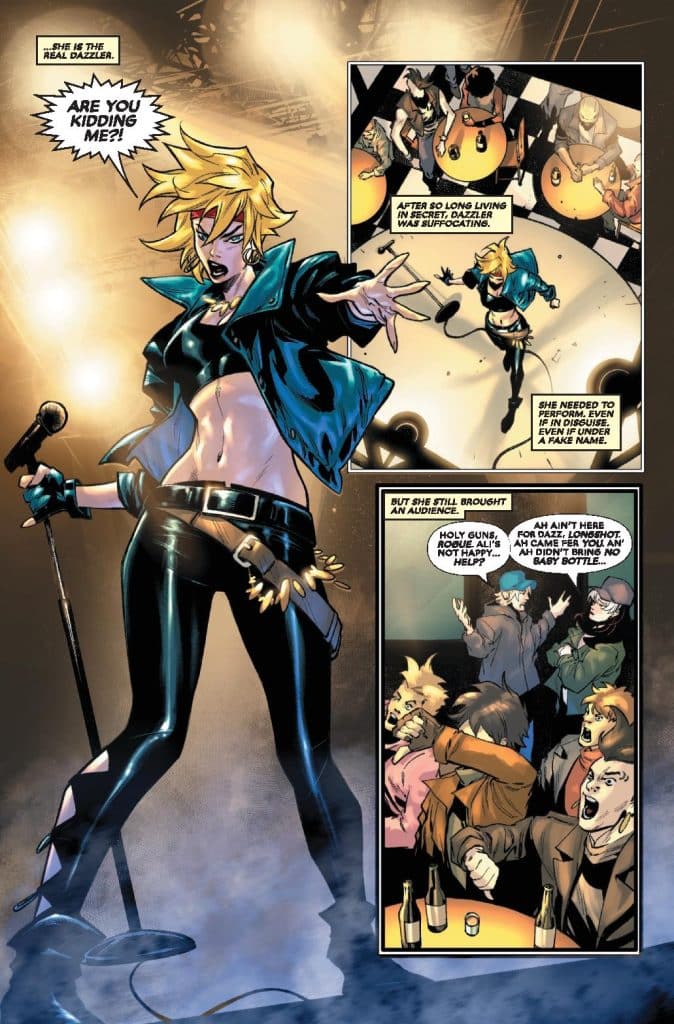 A comic panel featuring a blonde character dressed in a black leather outfit and a jacket, holding a microphone and performing on stage. The background shows a lively crowd at tables, reacting to the performance. There is dialogue in speech bubbles expressing excitement and humor about the situation.